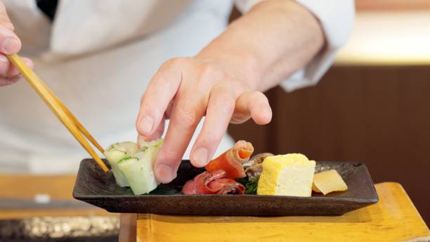 istock Chef's hands arranging food on a plate 2203163098