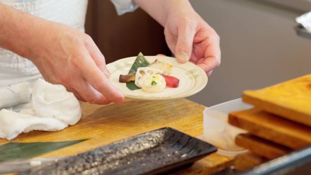 istock Chef's hands arranging food on a plate 2203163100