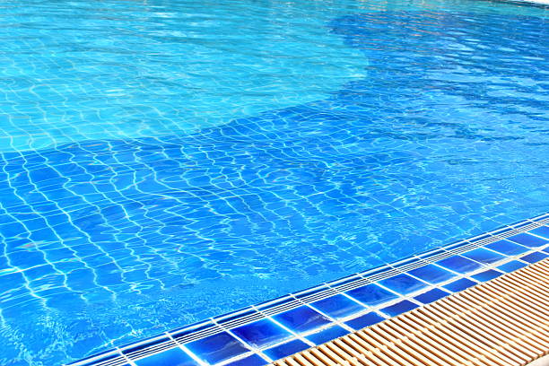 surface of blue swimming pool with water drain