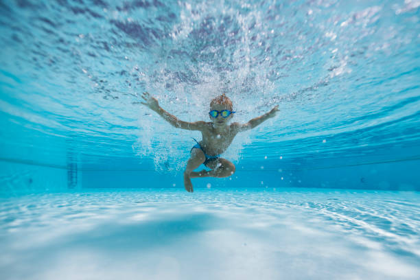 istock Cute little boy jumping and playing underwater in a pool 2203174742