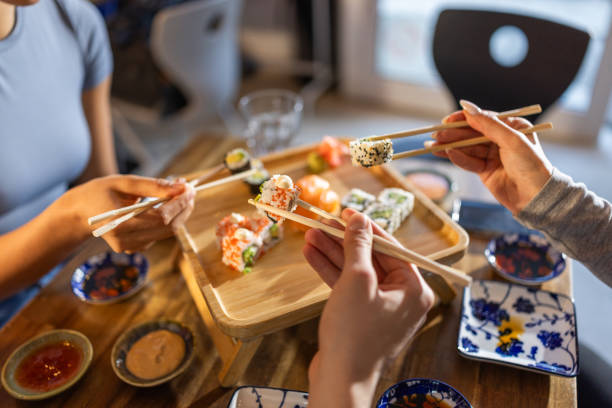 istock Young friends in sushi bar 2203177718