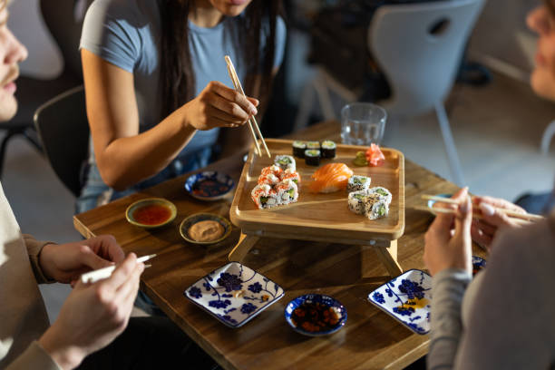 istock Young friends in sushi bar 2203177947