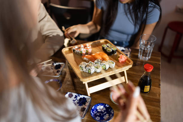 istock Young friends in sushi bar 2203178017