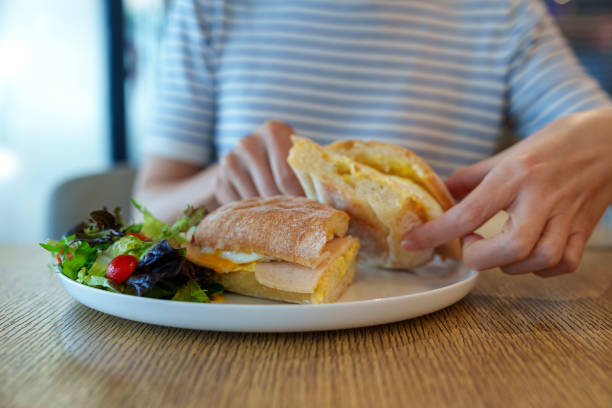 istock Breakfast Sandwich with Fresh Salad in a Cafe Setting 2203181238