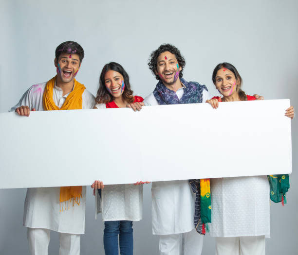 istock Happy friends with blank placard celebrating Holi on white background 2203181465
