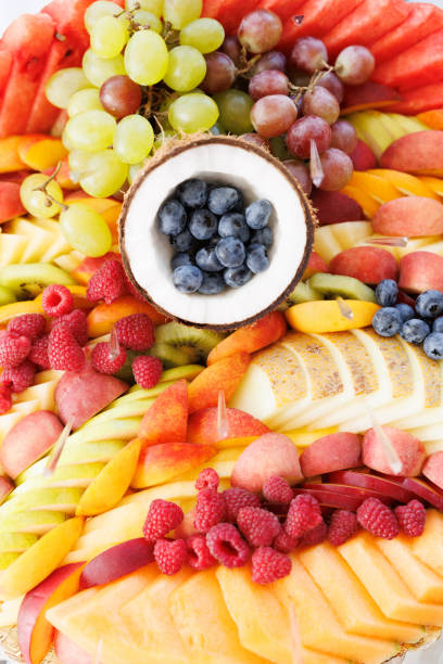 istock Colorful fruit platter featuring blueberries in coconut shell, raspberries, grapes, and sliced melon 2203181509