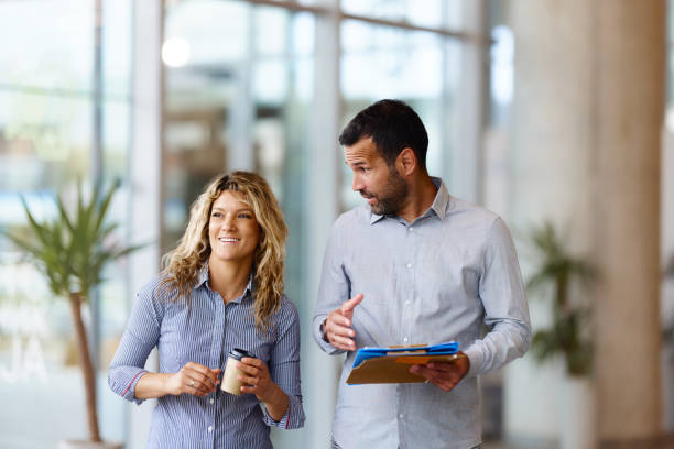 istock Happy business colleagues talking in a hallway. 2203185712