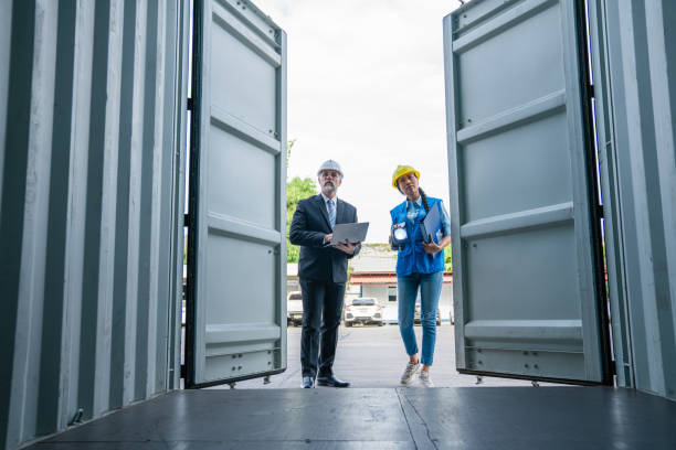 istock Container yard manager with safety hat talking to foreman 2203186587