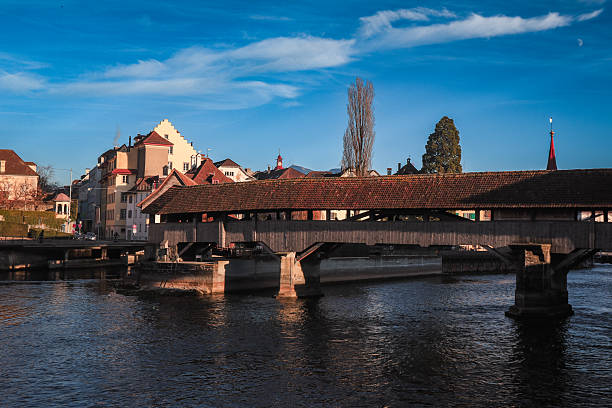 istock Luzern bridge reflecting serene water under a clear sky during late afternoon light 2203187446