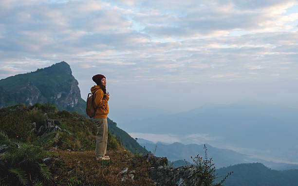 istock A woman standing on mountain peak on cloudy morning 2203188254