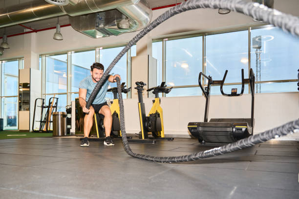 istock Man engaging in intense battle rope workout 2203189193