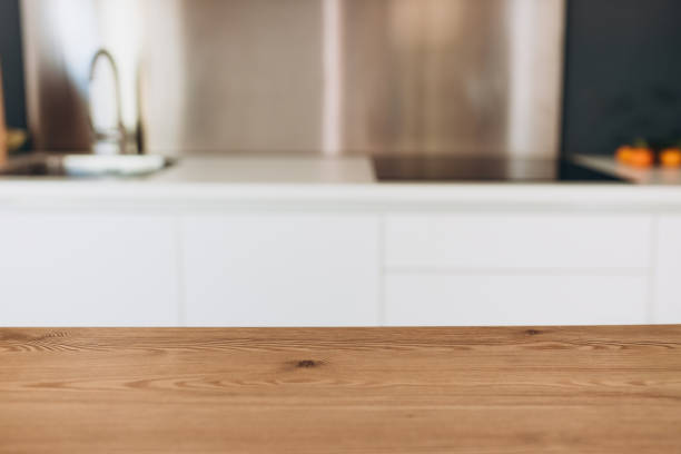 istock Empty wooden table with the bright white interior of the kitchen as a blurred background. For mock up 2203190234