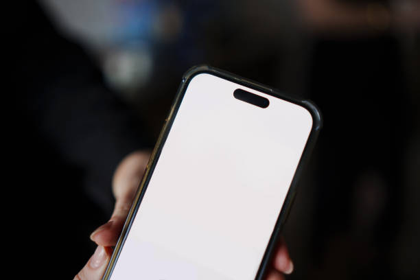 istock Smartphone held by a person in a social setting with a blank screen displayed 2203191108