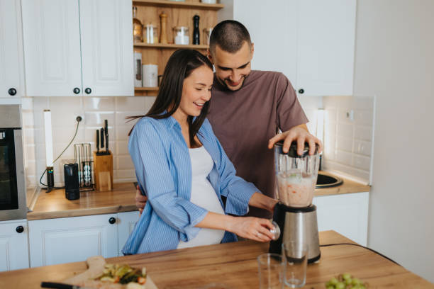istock Happy couple preparing healthy fruit smoothie at home 2203194230