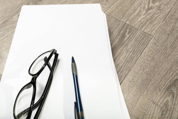 Blank notebook and pencil with glasses on wooden table