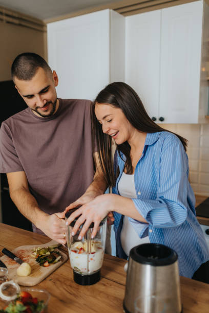 istock Happy couple preparing healthy fruit smoothie at home 2203195633