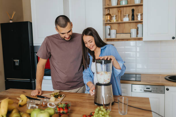 istock Happy couple preparing healthy fruit smoothie at home 2203195992