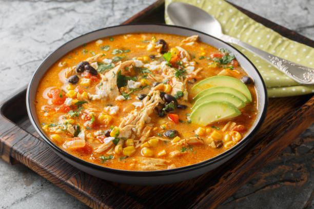 Creamy Mexican chicken enchilada black bean soup closeup on the plate. Horizontal