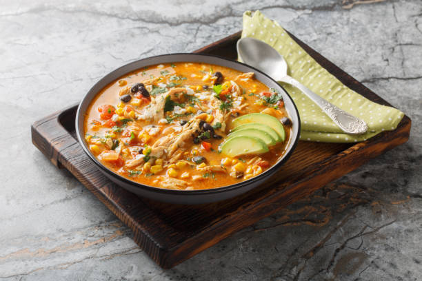 istock Delicious chicken enchilada soup with corn, tomato, avocado, black beans and cheese closeup on the plate. Horizontal 2203196839