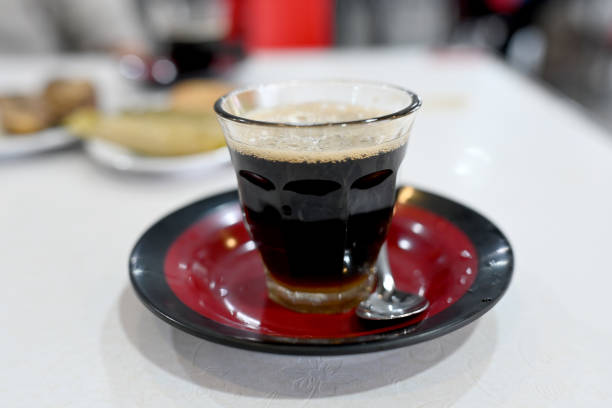 black coffee in a glass in a saucer on the table