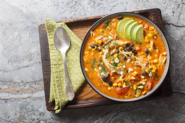 istock Delicious chicken enchilada soup with corn, tomato, avocado, black beans and cheese closeup on the plate. Horizontal top view 2203196873