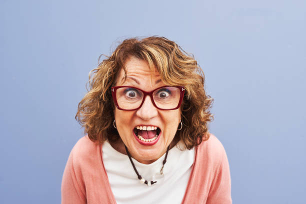 istock Excited senior woman with expressive face against blue background 2203197716