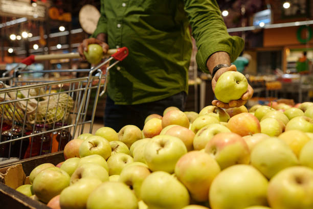 istock Close Up of Male Hand Taking Fresh Yellow Apple 2203198719