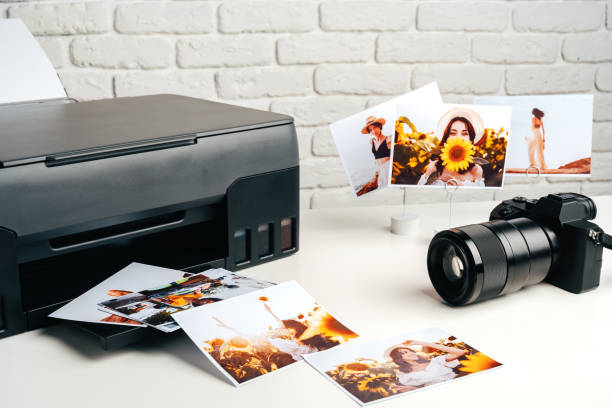 istock Printer and photo camera on table. Printing photos concept 2203200460