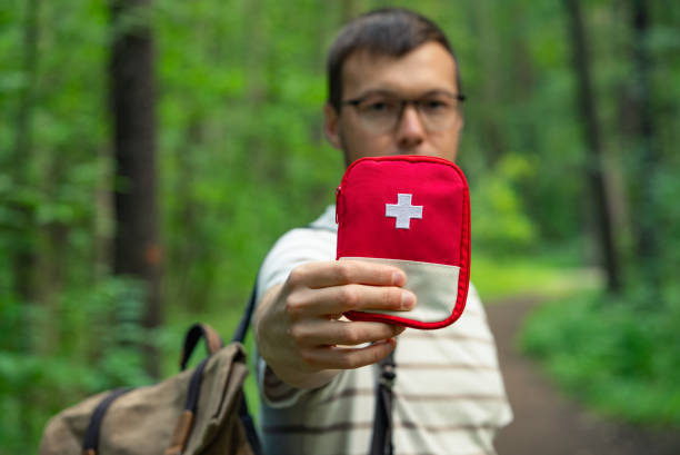 istock Hiker Holding Up First Aid Kit in Forest Emphasizing Outdoor Safety 2203201656