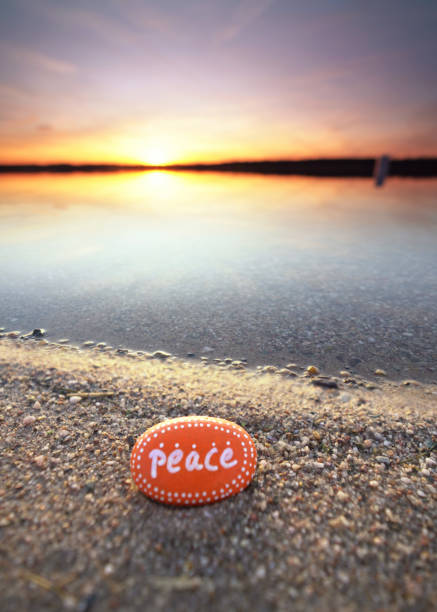 istock an orange colored peace stone on beach in sunset light in spring season 2203202504