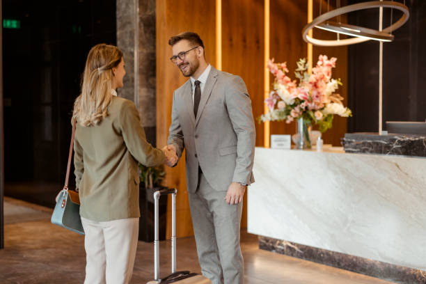 istock Professional Greeting: Two Business Colleagues Shaking Hands at a Hotel Reception 2203203900