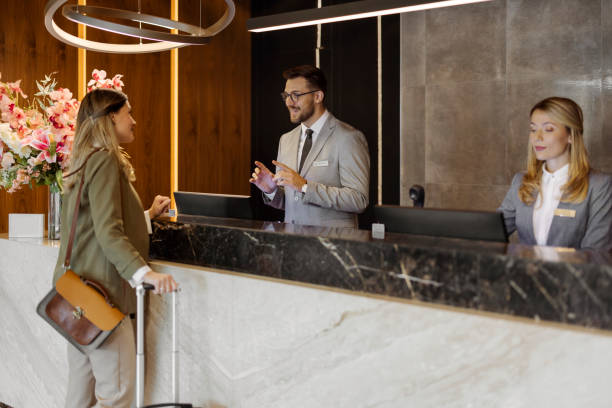 istock Receptionist Engaging with Visitor in a Well-Lit Hotel Lobby 2203203917
