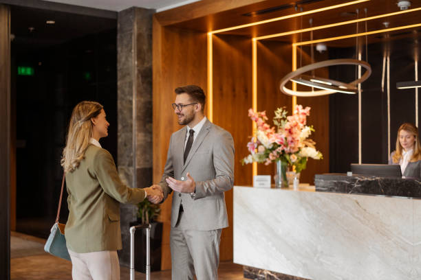 istock Professional Greeting: Two Business Colleagues Shaking Hands at a Hotel Reception 2203203968
