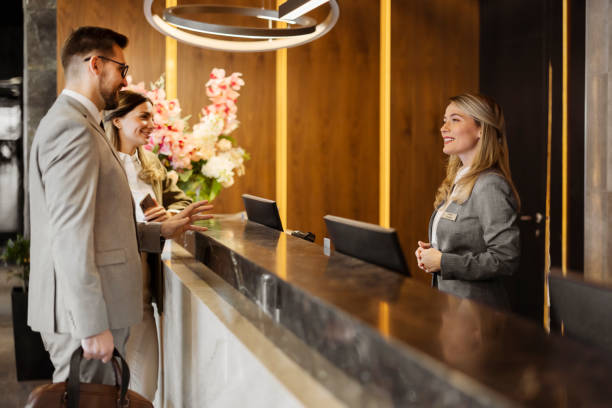 istock Stylish Welcome: Business Couple Checking In with Help from a Professional Concierge 2203204016