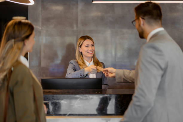 istock Friendly Receptionist Welcoming Guests at Hotel Front Desk 2203204026