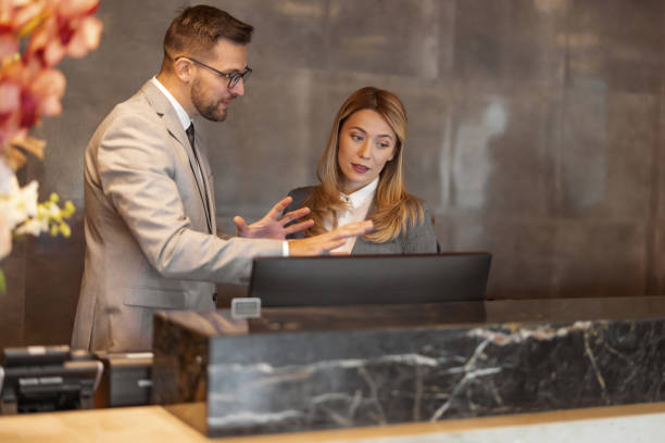 istock Team Collaboration: Hotel Manager Offering Guidance to a Front Desk Employee 2203204067
