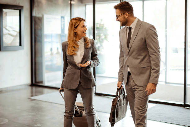istock Meeting in Motion: Business People Discussing Plans While Entering a Hotel 2203204077
