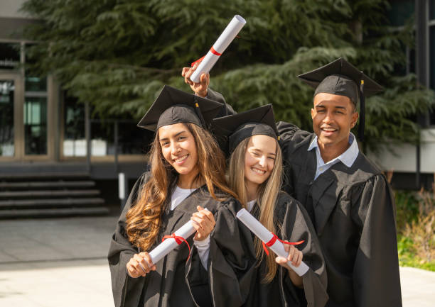 istock Smiling multiethnic graduated students celebrating with diplomas outdoors 2203205033