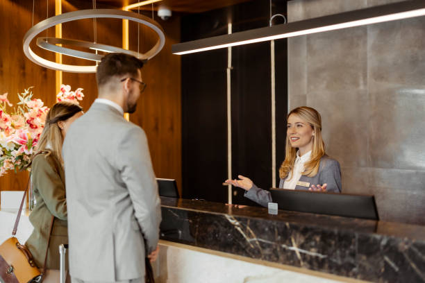 istock Stylish Welcome: Business Couple Checking In with Help from a Professional Concierge 2203205073