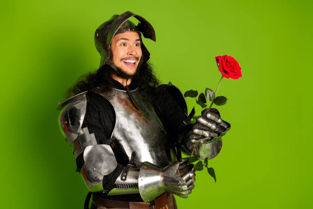 istock Armored Knight Holding Rose on Green Backdrop Highlighting Romance and Chivalry 2203206033