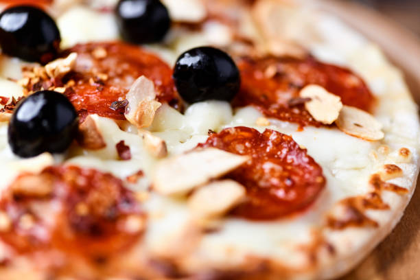 istock Pizza with salami and mozzarella cheese. Wooden background. Soft focus. Close up. 2203206077
