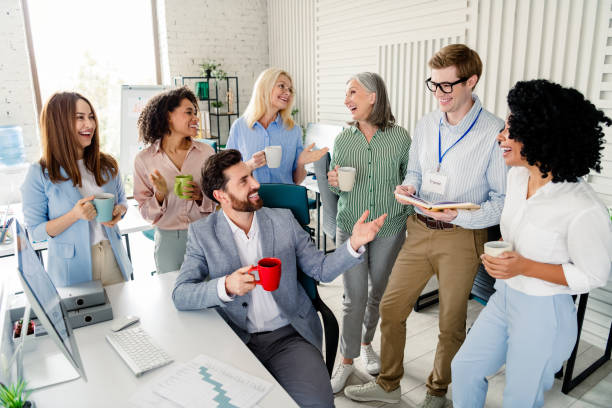 istock Group of professionals engaging in a cheerful conversation within an office setting during a coffee break 2203206962