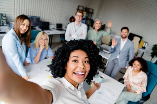 istock Friendly office team taking a group selfie in modern workspace, showing diverse professionals 2203206998