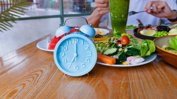 istock Alarm clock with IF (Intermittent Fasting) 16 and 8 diet rule and weight loss concept.-Diet plan concept 2203209695