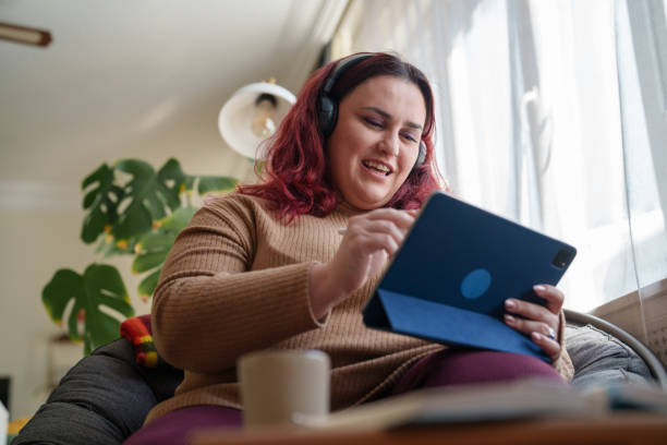 istock Young woman using headphones and digital tablet. 2203211532