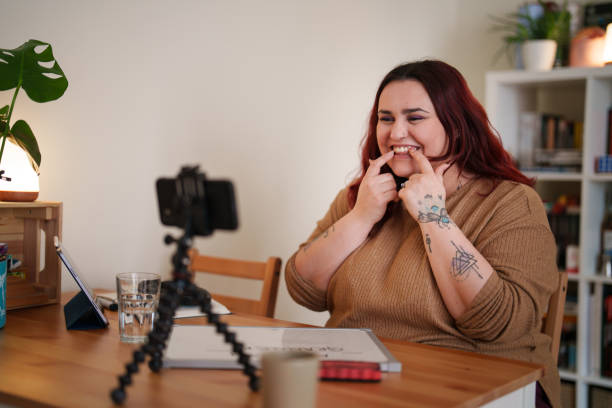 istock Female tutor giving online lessons at home, using mobile phone. 2203213118