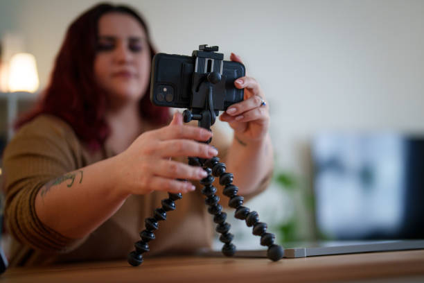 istock V-logger woman adjusting mobile phone for filming videos. 2203214743