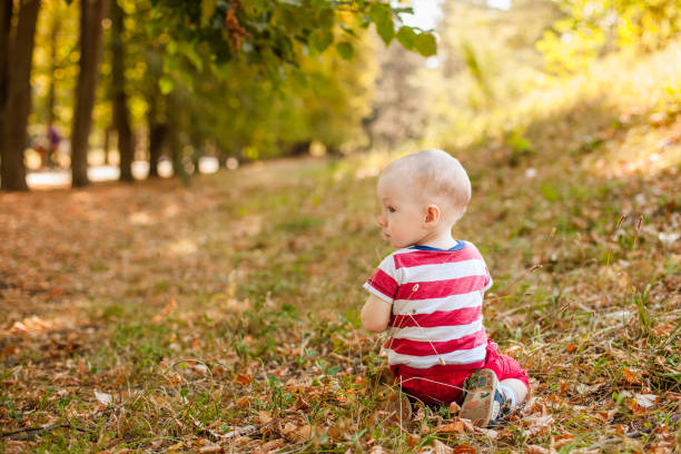 istock One-year-old little boy exploring the world in an autumn forest 2203217682