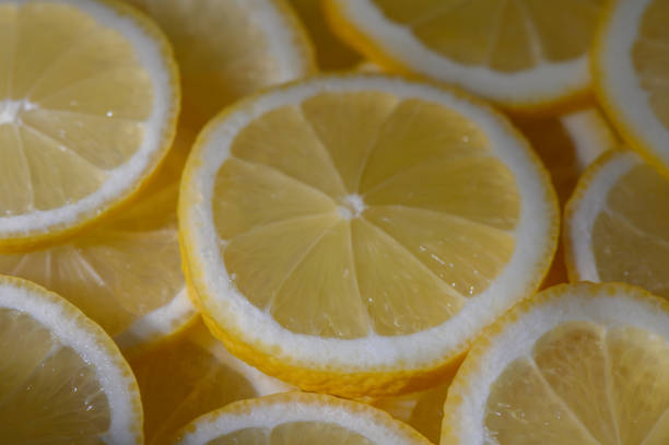 istock Freshly sliced lemons glisten under soft sunlight, creating a vibrant and refreshing display 2203218003