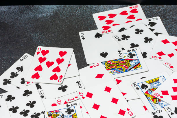 istock Scattered collection of playing cards, featuring various suits, numbers, and partial card faces. Chaotic arrangement creates a dynamic scene, symbolizing the unpredictability and thrill of card games 2203220982